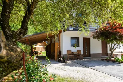 a house with a table and chairs in front of it at Apartma pri lipi in Bohinj