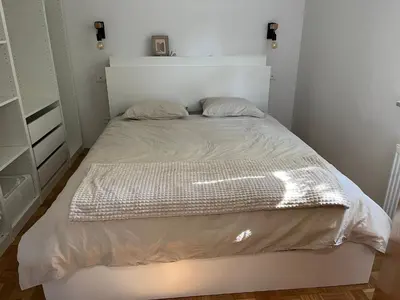 a small bedroom with a bed with a white headboard at Pod Galetovcem in Bohinjska Bela