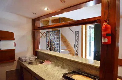 a kitchen with a counter with a sink and a staircase at Posestvo Brinje in Gradiček