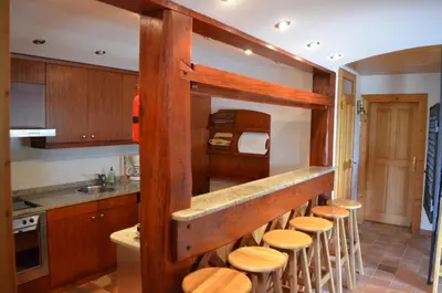 a kitchen with a bunch of wooden stools at Posestvo Brinje in Gradiček