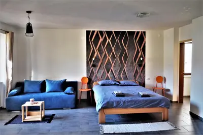 a living room with a bed and a couch at OLD SQUARE HOUSE - HIŠA NA STAREM TRGU in Tolmin