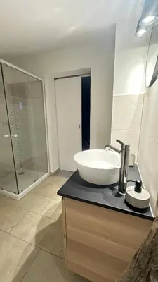 a bathroom with a sink and a glass shower at OLD SQUARE HOUSE - HIŠA NA STAREM TRGU in Tolmin