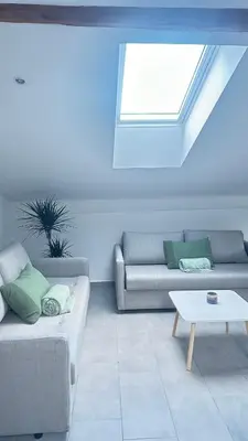 a living room with two couches and a window at OLD SQUARE HOUSE - HIŠA NA STAREM TRGU in Tolmin