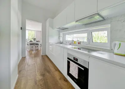 a kitchen with white countertops and a dining room at Apartments Trnovo in Ljubljana