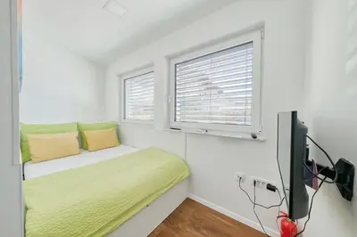 a small bedroom with a bed and a window at Apartments Trnovo in Ljubljana