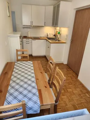 a kitchen with a wooden table and two chairs at Apartments Old Town in Ljubljana