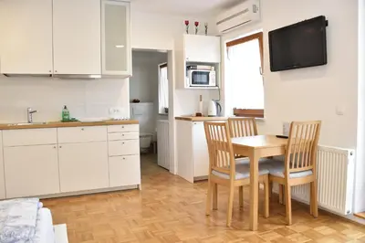 a kitchen with a table and two chairs and a sink at Apartments Old Town in Ljubljana