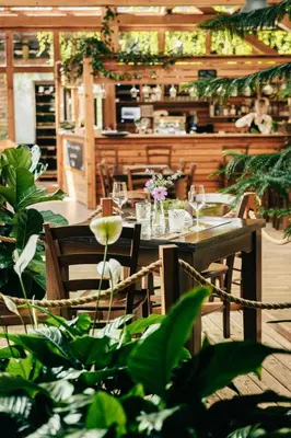 a table and chairs in a restaurant with plants at Garden Village Bled in Bled