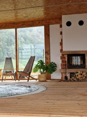 a living room with two chairs and a fireplace at Guesthouse Jelenov greben in Podčetrtek