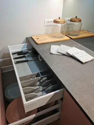 a kitchen counter with an open drawer with utensils at Riverside apartment in Ljubljana