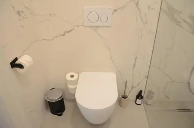 a white toilet in a bathroom with marble walls at Riverside apartment in Ljubljana