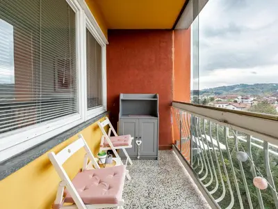 a balcony with two chairs and a television at Apartma Vrtnica 5th floor in Nova Gorica