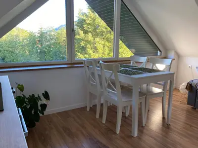 a dining room with a table and chairs and a window at Apartment Židana marela - Attic with a View in Kranjska Gora
