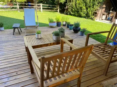 a wooden deck with two benches and potted plants at Apartment Židana marela - Attic with a View in Kranjska Gora