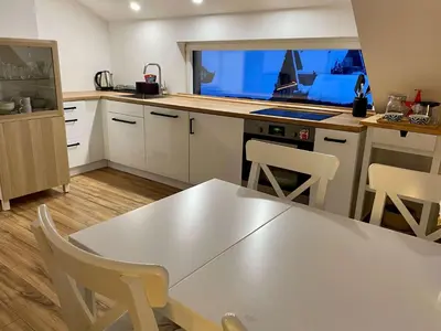 a kitchen with a table and chairs and a window at Apartment Židana marela - Attic with a View in Kranjska Gora