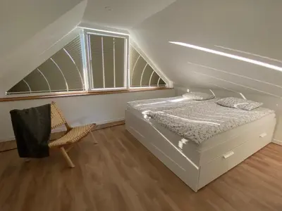 a bedroom with a bed and a chair in it at Apartment Židana marela - Attic with a View in Kranjska Gora