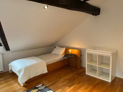 a small bedroom with a bed and a night stand at Riverside Villa Avo - Apartment Sara in Spodnja Idrija