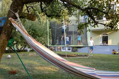 a group of children playing on a swing in a yard at Riverside Villa Avo - Apartment Sara in Spodnja Idrija