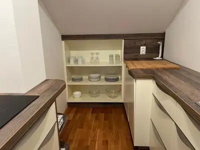 a kitchen with white cabinets and wooden floors at Riverside Villa Avo - Apartment Sara in Spodnja Idrija