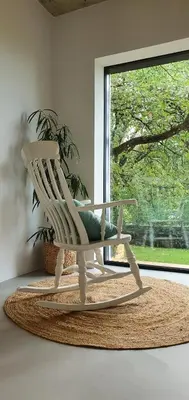 a white rocking chair in front of a window at HOUSE G in Dekani