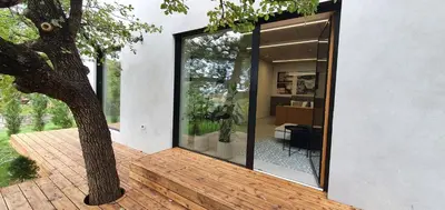a house with a large glass door on a deck at HOUSE G in Dekani