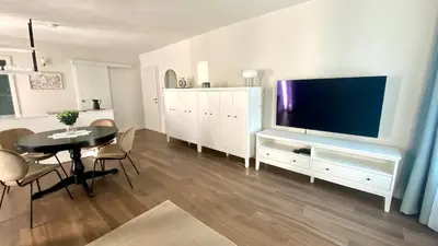 a living room with a table and a large television at Aria Apartments in Kojsko