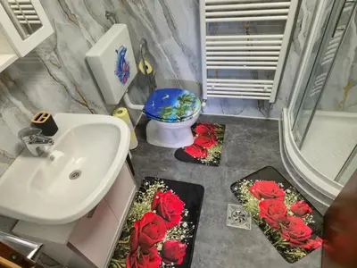 a bathroom with a sink and red roses on the floor at APARTMENt ANAYA in Bovec