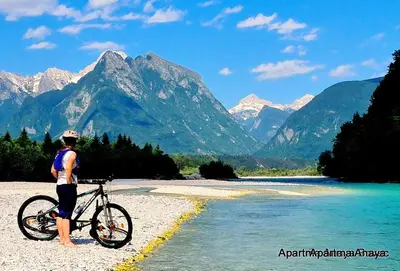 a man standing next to a bike on a river at APARTMENt ANAYA in Bovec