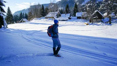 a person with a backpack standing in the snow at Chalet Hike&Bike above Bohinj valley in Bohinj