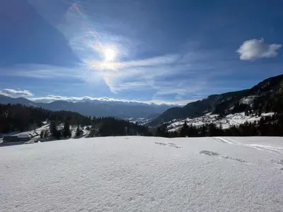 a snow covered mountain with the sun in the sky at Chalet Hike&Bike above Bohinj valley in Bohinj