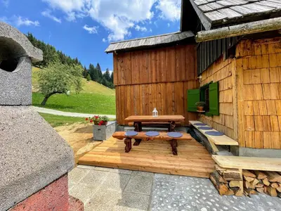 a wooden cabin with a picnic table on a deck at Chalet Hike&Bike above Bohinj valley in Bohinj
