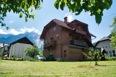 a house with a car parked in front of it at Apartma Vila Kočna in Zgornje Jezersko