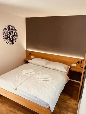 a bedroom with a bed with a tree picture on the wall at PJagodic Hotel Cerklje - 5min to Airport - Free Parking in Cerklje na Gorenjskem