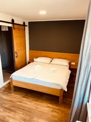 a bedroom with a bed with white sheets and pillows at PJagodic Hotel Cerklje - 5min to Airport - Free Parking in Cerklje na Gorenjskem