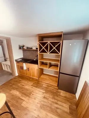 a kitchen with a refrigerator and wooden floors at PJagodic Hotel Cerklje - 5min to Airport - Free Parking in Cerklje na Gorenjskem
