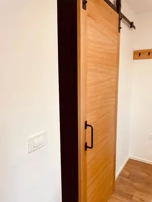 a wooden door is open in a room at PJagodic Hotel Cerklje - 5min to Airport - Free Parking in Cerklje na Gorenjskem