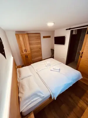 a bedroom with a large bed with white sheets at PJagodic Hotel Cerklje - 5min to Airport - Free Parking in Cerklje na Gorenjskem