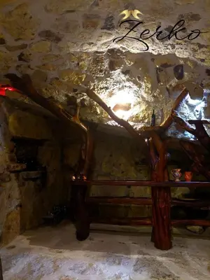 a wooden bed in a cave with a tree on it at Zerko Holiday Home - Vineyard Chalet With Sauna and Jacuzzi FREE in Mirna