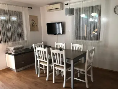 a dining room with a black table and white chairs at Spa House Lotus in Terme Čatež in Čatež ob Savi