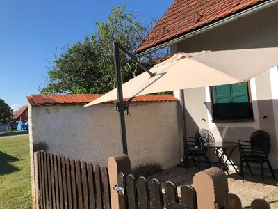 a white umbrella in front of a house at Spa House Lotus in Terme Čatež in Čatež ob Savi