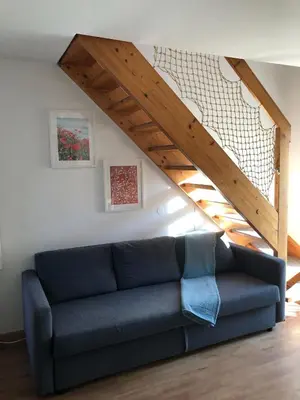 a blue couch in a living room with a staircase at Spa House Lotus in Terme Čatež in Čatež ob Savi