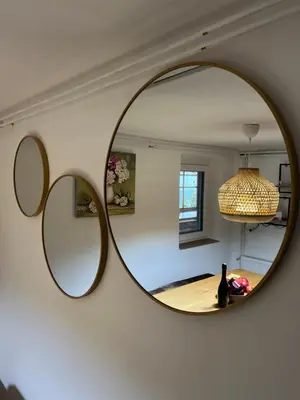 a mirror hanging on a wall in a living room at Vineyard cottage Skriti raj in Leskovec pri Krškem
