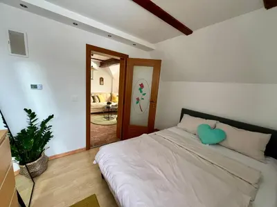 a bedroom with a bed with a heart pillow on it at Vineyard cottage Skriti raj in Leskovec pri Krškem