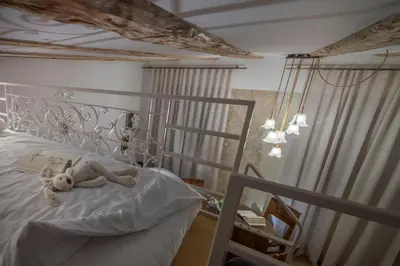a teddy bear laying on a bed in a bedroom at KariNatura in Ljubljana