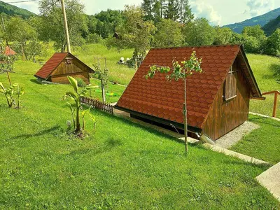 a small house with a red roof in the grass at Krampez in Kobarid