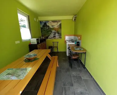 a kitchen with green walls and a wooden table at Krampez in Kobarid