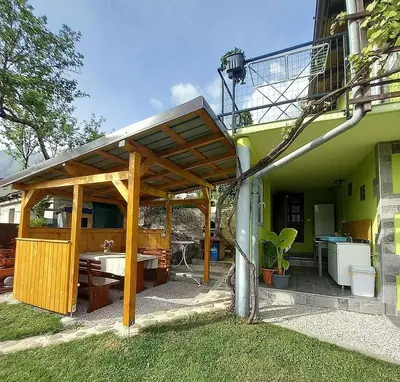 a wooden pergola on the side of a house at Krampez in Kobarid