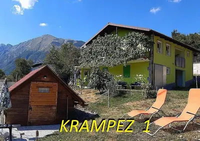 a yellow house with two chairs in front of it at Krampez in Kobarid