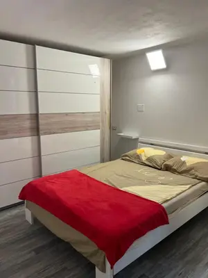a bedroom with a bed with a red blanket on it at Apartma Ročica Dejan Uršič sobodajalec in Kobarid