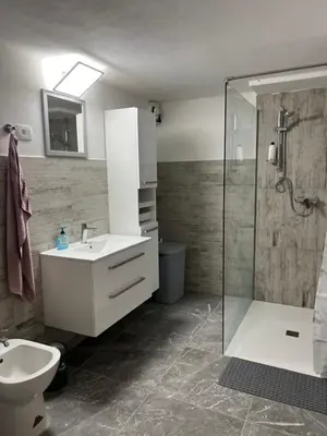 a bathroom with a white sink and a shower at Apartma Ročica Dejan Uršič sobodajalec in Kobarid